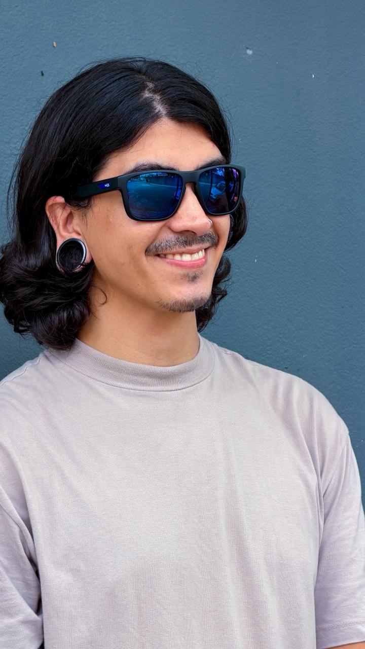 Homem jovem usando óculos de sol com lentes espelhadas azuis