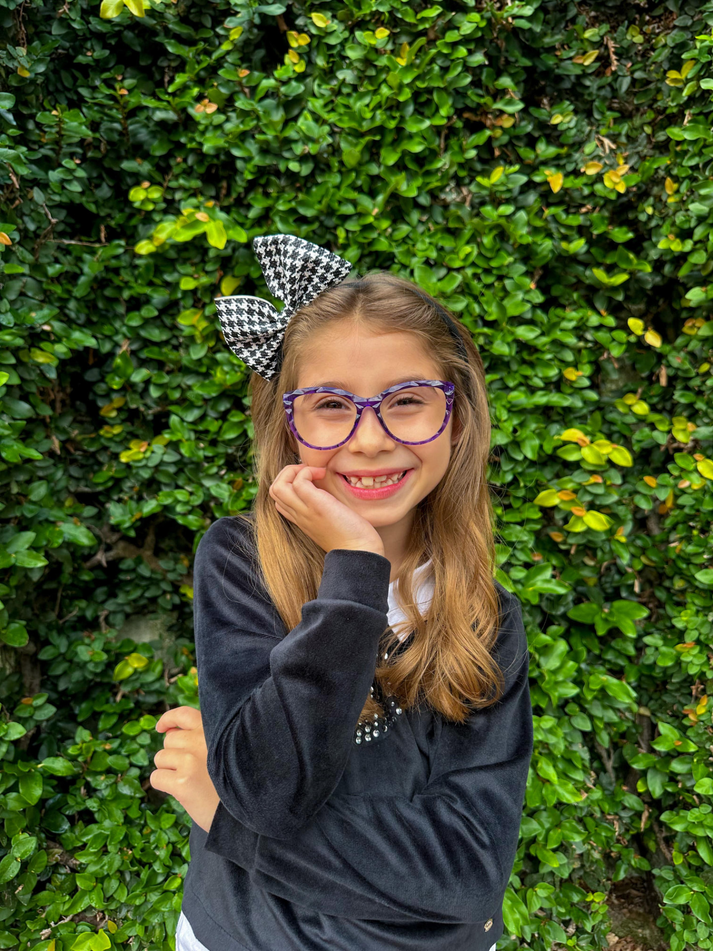 Menina usando óculos de grau com armação roxa estampada